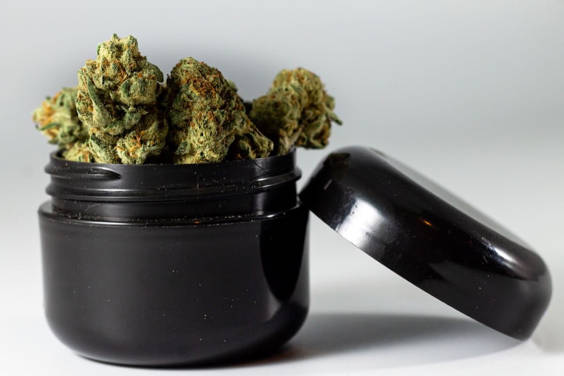 An unbranded black jar of cannabis flower